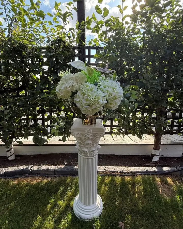 An ornate display pillar with decorative detailing for a more traditional, classical look. Adds architectural elegance to ceremony setups, entrance displays, and reception focal points. The carved detail catches light beautifully in photos.